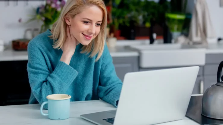 woman in blue sweater looks at computer while shopping natural gas plans in Pennsylvania