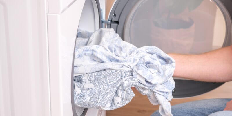 man removing clothes from a dryer